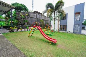 a playground with a red slide in a yard at Naava Village in Tagalbato