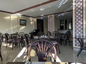 a restaurant with wooden tables and chairs and tables and chairsearcher at Saala Hotel Limited in Gatunga
