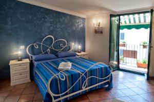 a bedroom with a blue and white bed and a window at CETARA - ALBERGO DIFFUSO in Cetara
