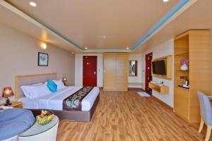 a hotel room with a bed and a tv at Season Paradise in Thulusdhoo