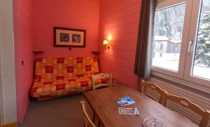 Zimmer mit Tisch und Bett in der Unterkunft Résidence Vacancéole Les Monts Jura in Lélex