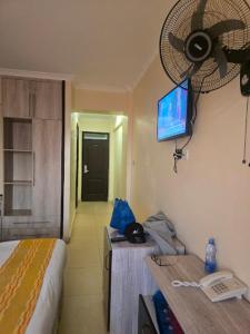a room with a bed and a television on the wall at Saala Hotel Limited in Gatunga +2 photos