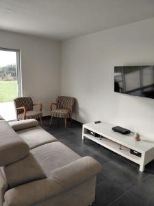 een woonkamer met een bank en een tafel bij Gîte du champ aisé in Montaigu-Vendée