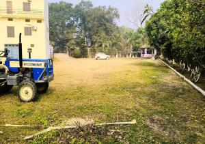 un camion bleu garé dans un champ à côté d'une maison dans l'établissement Hotel ShivDham Naimisharanya, à Naimishāranya