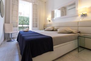 1 dormitorio con 1 cama grande y espejo en la pared en Le Blanc Apart, en Sitges