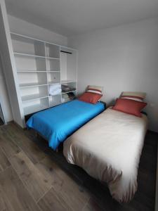 twee bedden naast elkaar in een kamer bij Gîte du champ aisé in Montaigu-Vendée