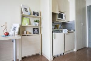 cocina con armarios blancos y microondas en Residencia Universitaria Blas De Otero, en Bilbao