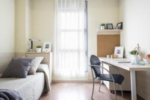 a bedroom with a bed and a desk with a chair at Residencia Universitaria Blas De Otero in Bilbao