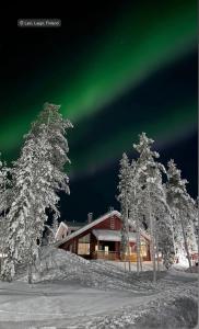 ein Bild der Aurora Borealis am Himmel über einer Lodge in der Unterkunft Auroralevi Sointuilevi B63, Central, Sauna, Ski nearby in Levi