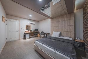 ein Schlafzimmer mit einem Bett und einem Schreibtisch in der Unterkunft V Hotel in Gumi