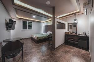 ein Zimmer mit einem Bett und einem Tisch und einem Schreibtisch in der Unterkunft V Hotel in Gumi