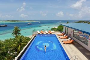 a woman is standing in a swimming pool at a resort at Season Paradise in Thulusdhoo
