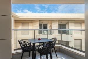 a table and chairs on a balcony with a view of a building at Valencia Beach Vibe by Vireta Suites in Valencia