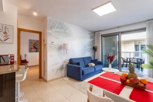 a living room with a blue couch and a table at Valencia Beach Vibe by Vireta Suites in Valencia +14 photos