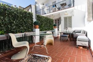 un patio con mesa y sillas en un edificio en Le Blanc Apart, en Sitges