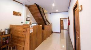 ein Flur mit Holzschränken und Treppen in einem Gebäude in der Unterkunft Thongphaphum Place in Thong Pha Phum