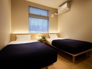 En eller flere senge i et værelse på Minn house Niseko Hirafu