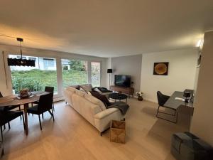 un salon avec un canapé et une table dans l'établissement Feel Home Apartments - Seeblick - Bergblick - Parkplatz, à Emmetten