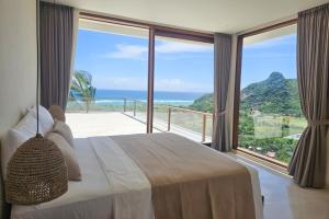 a bedroom with a bed and a view of the ocean at SABA Lombok in Selong Belanak