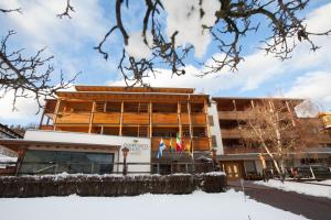 a building with snow in front of it at Olimpionico Hotel in Castello di Fiemme