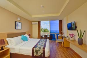 a hotel room with a bed and a view of the ocean at Season Paradise in Thulusdhoo