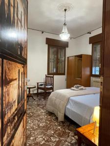 ein Schlafzimmer mit einem Bett, einem Tisch und einem Stuhl in der Unterkunft Residenze Rodari Altedo Affittacamere in Altedo