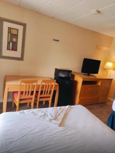 une chambre avec un lit, une table et un bureau dans l'établissement Niagara Best Inn, à Niagara Falls