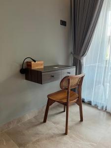 een houten stoel voor een bureau bij Adiuma Cottage Ubud in Ubud