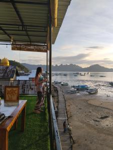 a woman standing on the beach looking at the water at Komodo Village Tour & Homestay in Komodo
