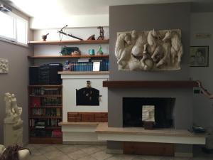 Villa Abati في Collepasso: غرفة معيشة بها موقد و لوحة على الحائط
