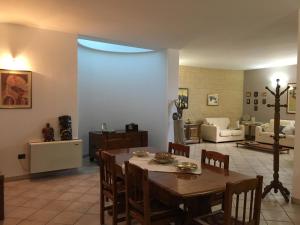 uma sala de jantar com uma mesa e uma sala de estar em Villa Abati em Collepasso