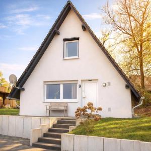 a white house with a gambrel roof at Ferienhaus Seeblick Westerwald in Mengerskirchen