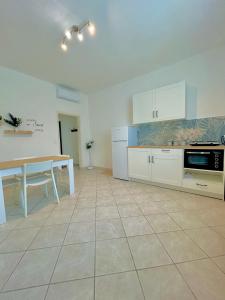 een keuken met witte kasten en een tafel. bij Home Sweet Home Forli in Forlì +7 foto's