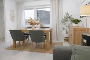 a dining room table and chairs in a living room at Ferienhaus Seeblick Westerwald in Mengerskirchen +24 photos