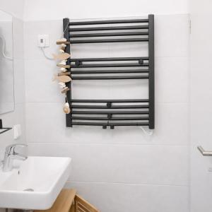 a bathroom with a sink and a towel rack at Ferienhaus Seeblick Westerwald in Mengerskirchen