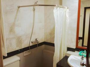 a bathroom with a shower curtain and a sink at Hotel Yasmin in Jayapura +69 photos
