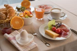 a table topped with plates of breakfast foods and orange juice at Blümlisalp in Kandersteg