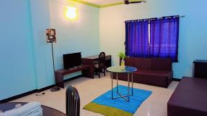 ein Wohnzimmer mit Sofa und Tisch in der Unterkunft Sai Dwarka Alibag Hotel in Alibag
