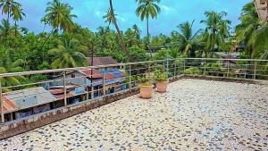 einen Balkon eines Hauses mit Palmen in der Unterkunft Sai Dwarka Alibag Hotel in Alibag