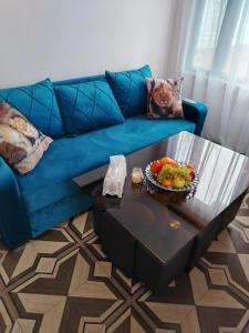 een blauwe bank met een tafel met een fruitschaal bij Сказочный Дилижан in Dilidzjan