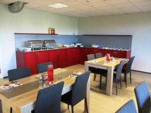 a dining room with tables and chairs and a kitchen at Männiku JK in Tallinn
