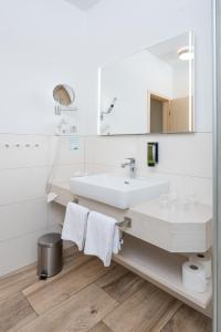 une salle de bains avec un lavabo et un miroir dans l'établissement Hotel Haus am Meer, à Graal-Müritz 57 autres photos