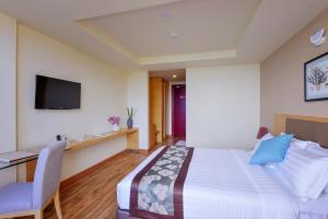 a bedroom with a bed and a desk and a tv at Season Paradise in Thulusdhoo