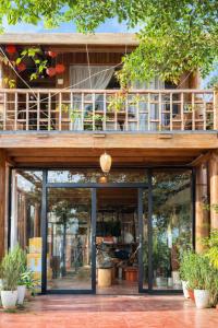 un bâtiment avec un balcon au-dessus dans l'établissement Cô Ba Homestay Măng Đen, à Kon Von Kla