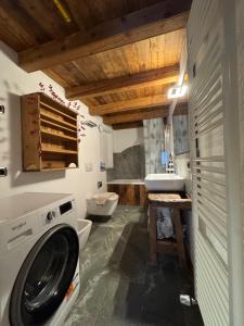 a bathroom with a washing machine and a sink at We Are 4810 LA CORDE D'ESCALADE in Courmayeur