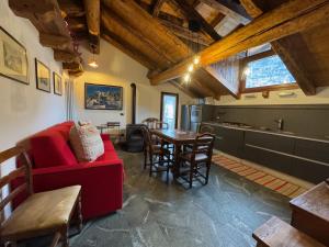 a living room with a red couch and a table at We Are 4810 LA CORDE D'ESCALADE in Courmayeur