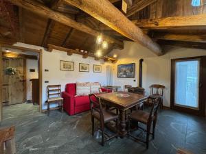 a living room with a red couch and a table at We Are 4810 LA CORDE D'ESCALADE in Courmayeur