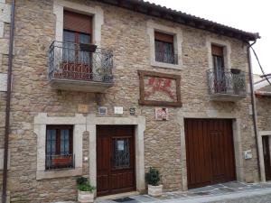 a stone building with two doors and a balcony at La Juderia de Las Arribes in Vilvestre