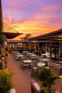 an outdoor patio with tables and chairs at sunset at Epic Tower Swiss-Belresidences Hanoi in Hanoi