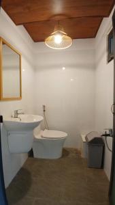 un bagno con lavandino, WC e specchio di FB Farmstay - Vườn An Lành Bên Suối a B'sar